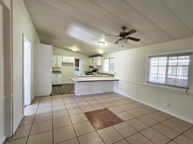 a large kitchen with stainless steel appliances kitchen island granite countertop a refrigerator and a sink