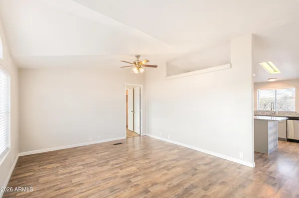 a view of a livingroom with wooden floor and a ceiling fan