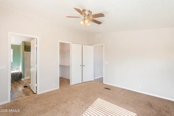 a big room with closet and a chandelier fan