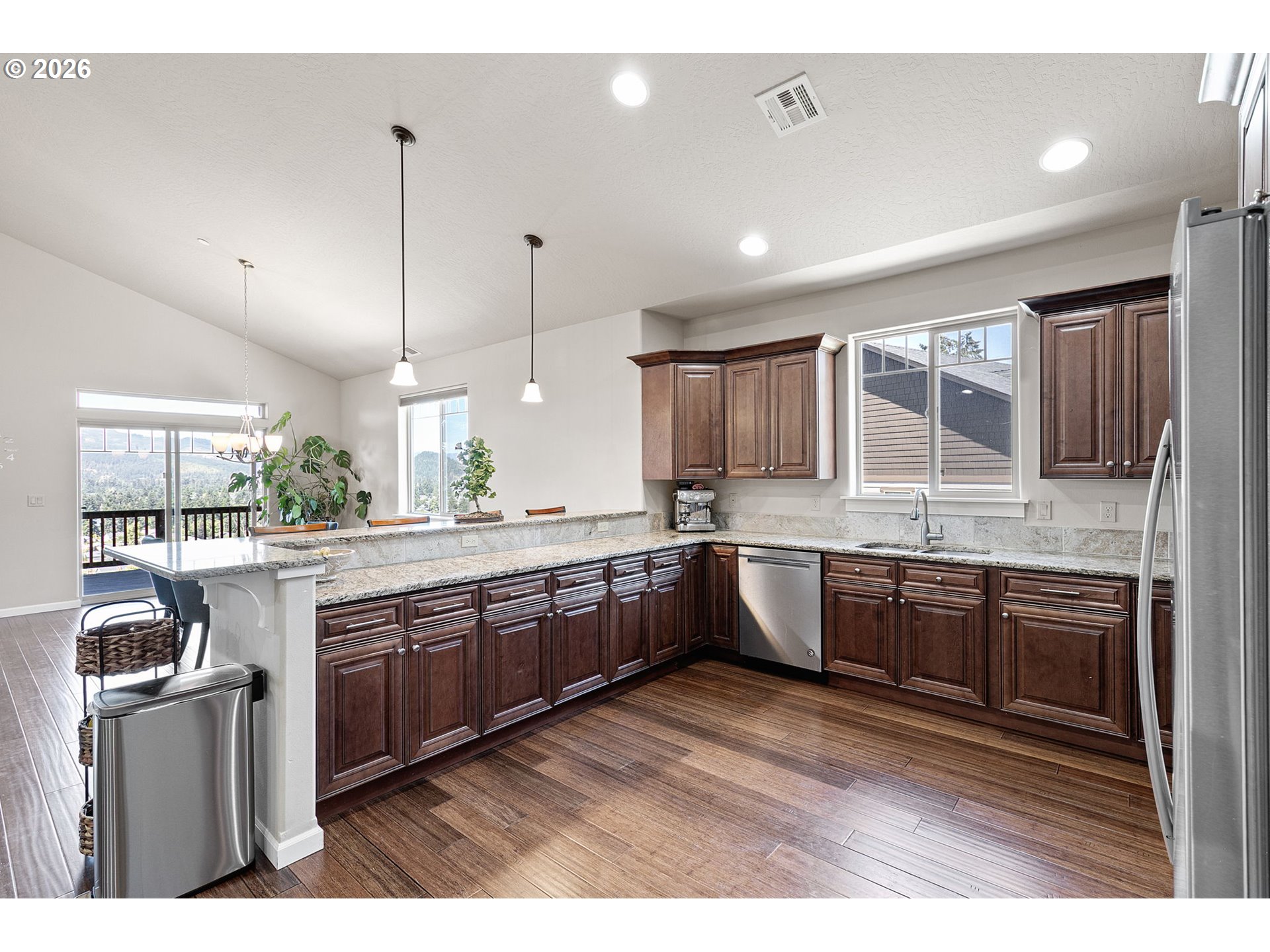 6451 Dogwood Street Springfield, OR 97478 - Photo 9 of 38 a large kitchen with kitchen island granite countertop a large counter top a sink stainless steel appliances and cabinets