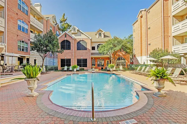 a view of a house with pool and chairs