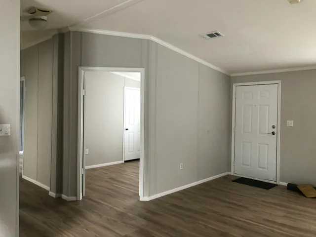 an empty room with wooden floor & closet area