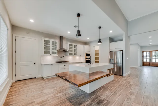 a large living room with stainless steel appliances granite countertop furniture wooden floor and a view of kitchen