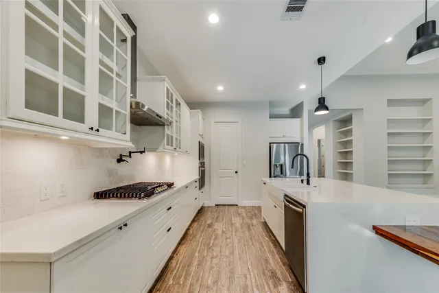 a kitchen with stainless steel appliances a stove a sink and a refrigerator