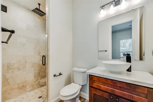 a bathroom with a sink a toilet and shower