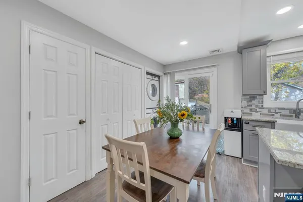 a kitchen with granite countertop white cabinets a table and chairs in it