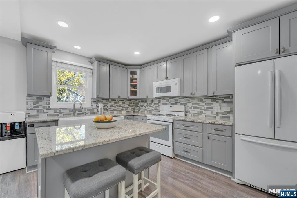 39 Delaware Road West Milford, NJ 07421 - Photo 17 of 37 a kitchen with stainless steel appliances granite countertop a refrigerator a sink dishwasher a stove and white cabinets with wooden floor