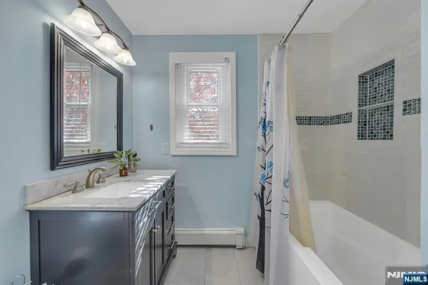 a backyard of a house with large trees and wooden fence