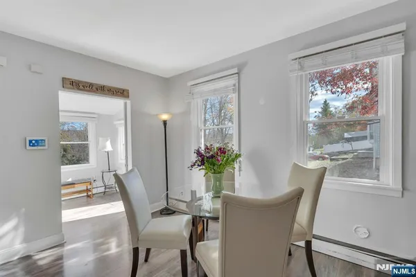 a living room with furniture and a flat screen tv with kitchen view