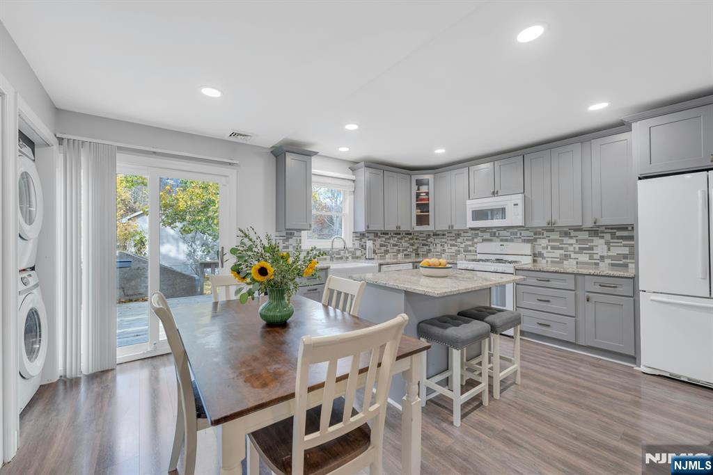 39 Delaware Road West Milford, NJ 07421 - Photo 10 of 37 a kitchen with stainless steel appliances granite countertop a stove a refrigerator a microwave oven a dining table and chairs with wooden floor