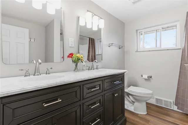 a bathroom with a granite countertop sink a mirror and shower