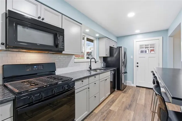 a kitchen with stainless steel appliances granite countertop a stove microwave and refrigerator