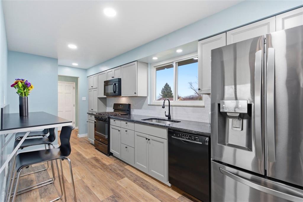 111 Crest Drive Monaca, PA 15061 - Photo 6 of 37 a kitchen with stainless steel appliances granite countertop a refrigerator a sink dishwasher a stove and white countertops with wooden floor