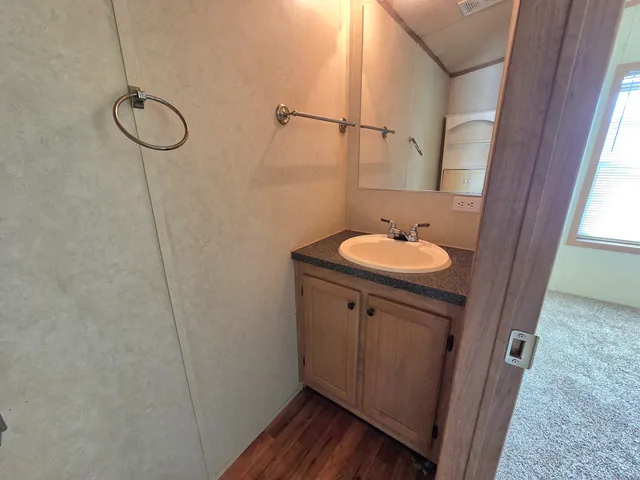 a bathroom with a granite countertop sink a toilet and shower