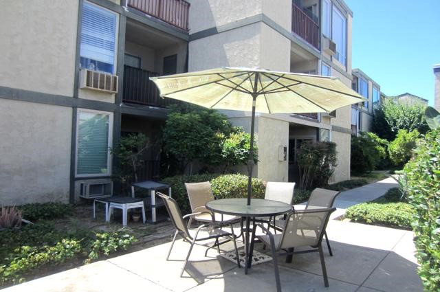 6675 Mission Gorge Road, Unit A114 San Diego, CA 92120 - Photo 20 of 26 a view of a patio with a table and chairs under an umbrella