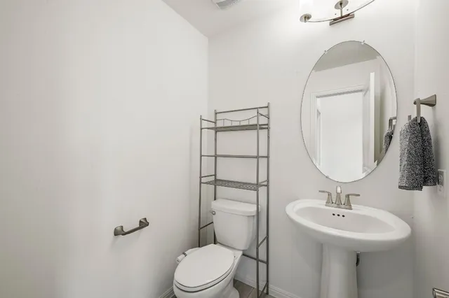 a bathroom with a sink toilet and a mirror