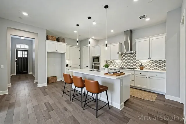 a kitchen with stainless steel appliances kitchen island granite countertop a table chairs sink and cabinets