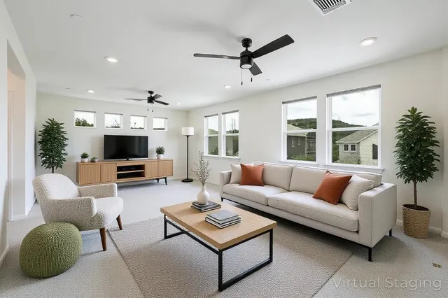 a living room with furniture a flat screen tv and a large window