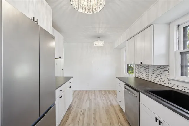 a kitchen with granite countertop white cabinets and white appliances