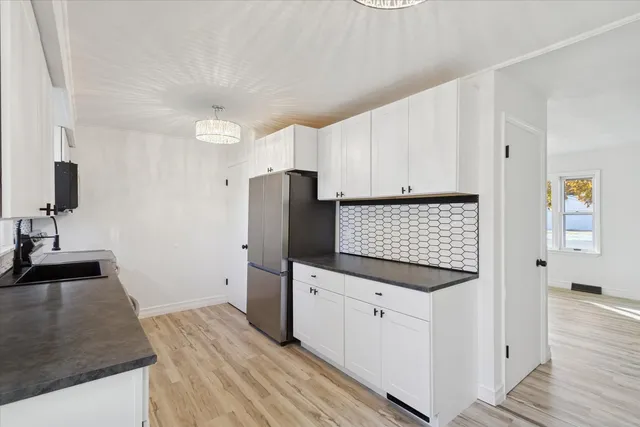 a kitchen with granite countertop white cabinets and stainless steel appliances