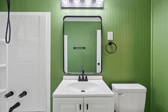 a bathroom with a sink a toilet and shower