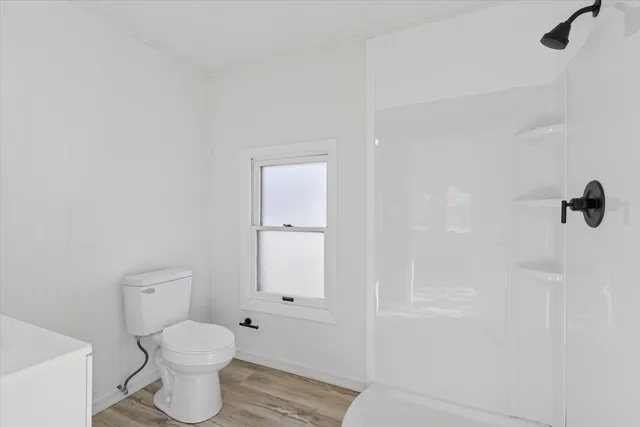 a bathroom with a toilet a sink and shower