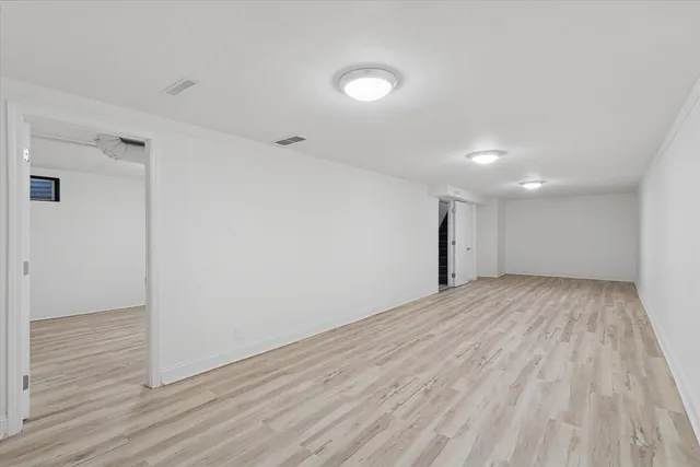 a view of empty room with wooden floor