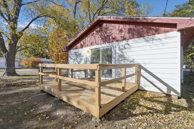 a view of a small house with wooden fence