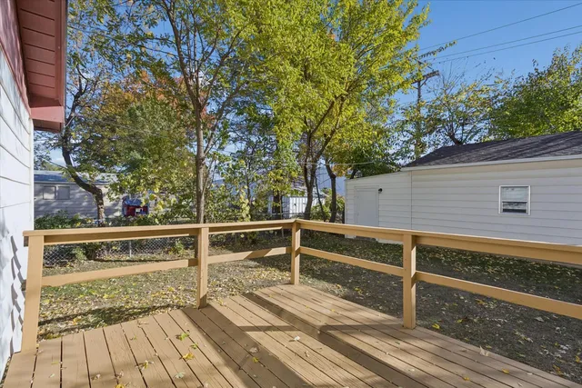 a view of balcony with wooden floor and fence and a bench