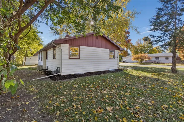 a backyard of a house with plants and large tree