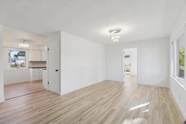 a view of empty room with wooden floor and windows