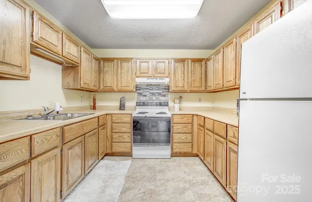 a kitchen with granite countertop white cabinets and white appliances