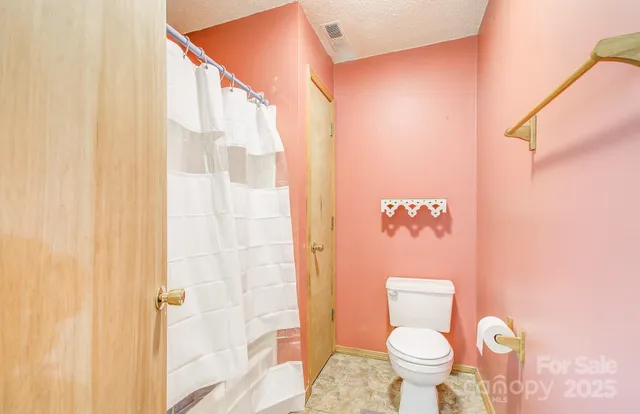 a bathroom with a toilet and a shower