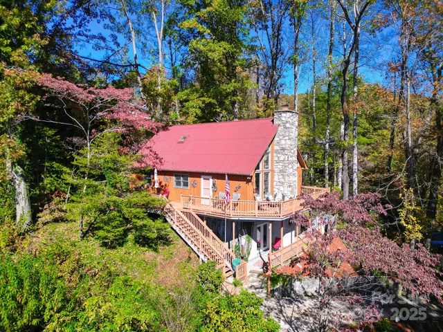 a view of a house with roof and wooden fence