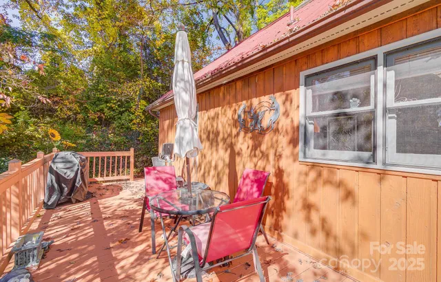 a balcony with table and chairs and potted plants