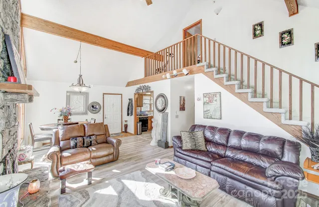 a living room with furniture a fireplace and a chandelier