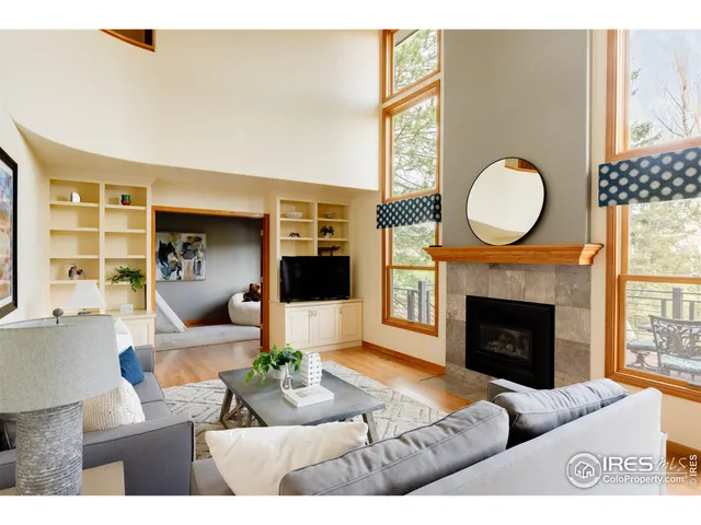 a living room with furniture a fireplace and a large window