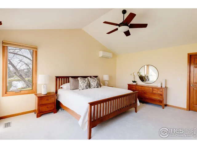 a bedroom with a bed and large windows