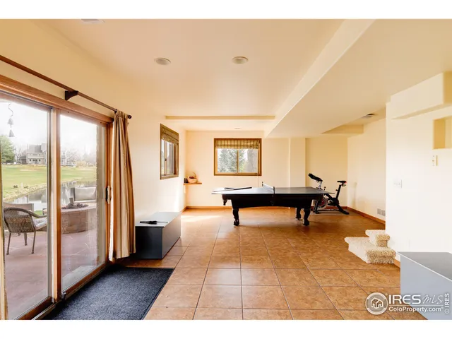 a living room with furniture a computer on the desk and a large mirror