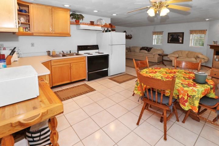 22441 Rockdale Road Cambridge Springs, PA 16403 - Photo 3 of 22 a kitchen with a sink a stove a dining table and chairs