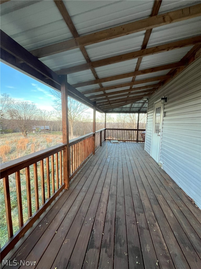 53720 Highway 681 Reedsville, OH 45772 - Photo 22 of 25 Expansive covered porch featuring wood-finish decking, a wooden railing, and a white metal roof
