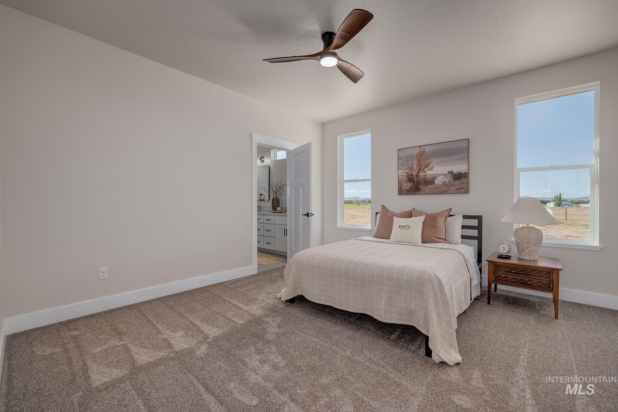 1371 Hansen Road Weiser, ID 83672 - Photo 19 of 44 Plush carpet flooring, a ceiling fan with integrated lighting, and multiple windows providing natural illumination