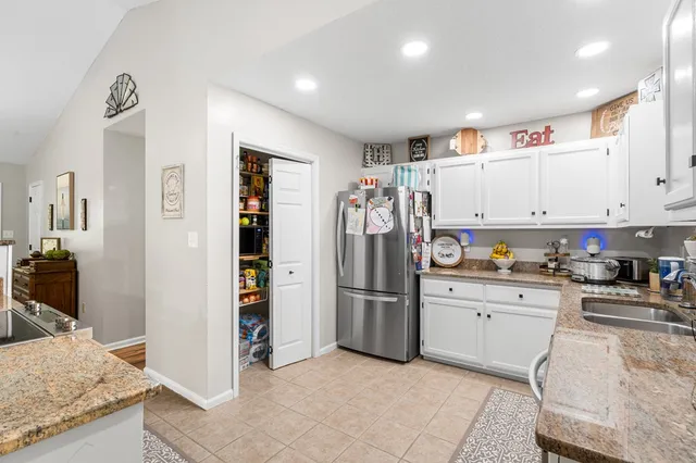 a kitchen with stainless steel appliances granite countertop a refrigerator and a stove top oven