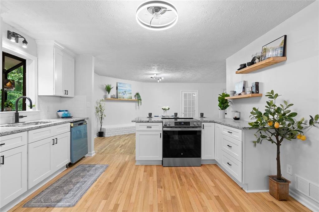 2984 East Paulding Drive Dallas, GA 30157 - Photo 26 of 35 a kitchen with kitchen island granite countertop a sink stainless steel appliances and cabinets