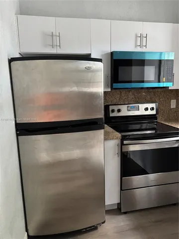 a stove top oven sitting inside of a kitchen