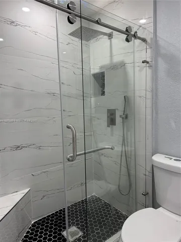 a bathroom with a toilet and a shower