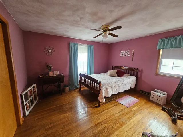 a bedroom with a bed dresser and a window