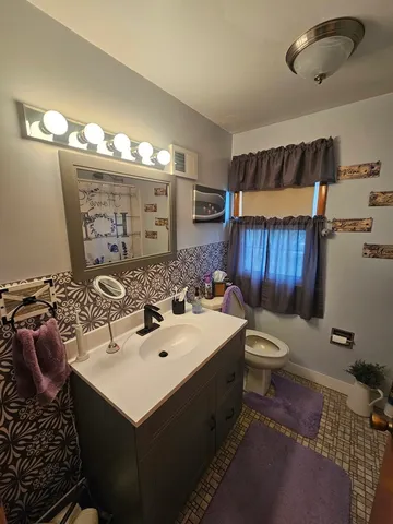 a bathroom with a sink toilet and mirror