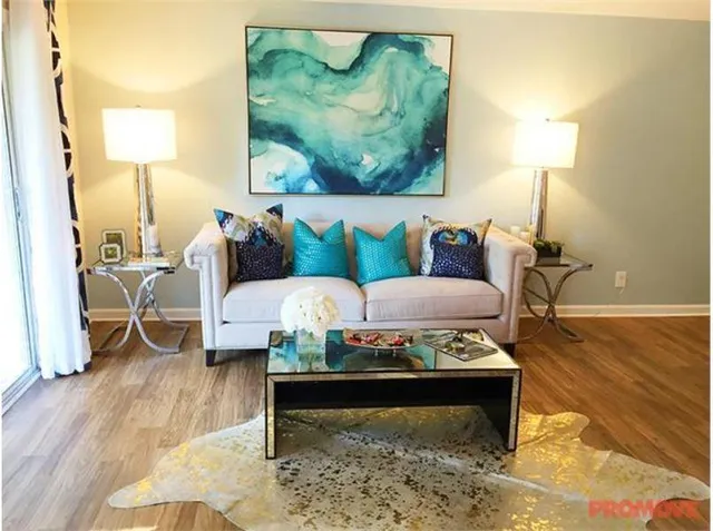 a living room with furniture and a wooden floor