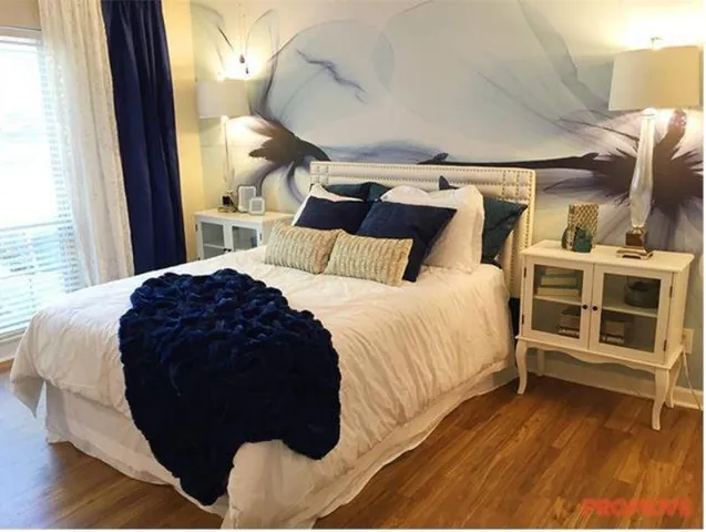 a large bed sitting in a bedroom next to a window